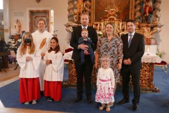 Die Familie Breu mit dem Täufling, dem Paten, Diakon Thomas Bauer und den Ministrantinnen